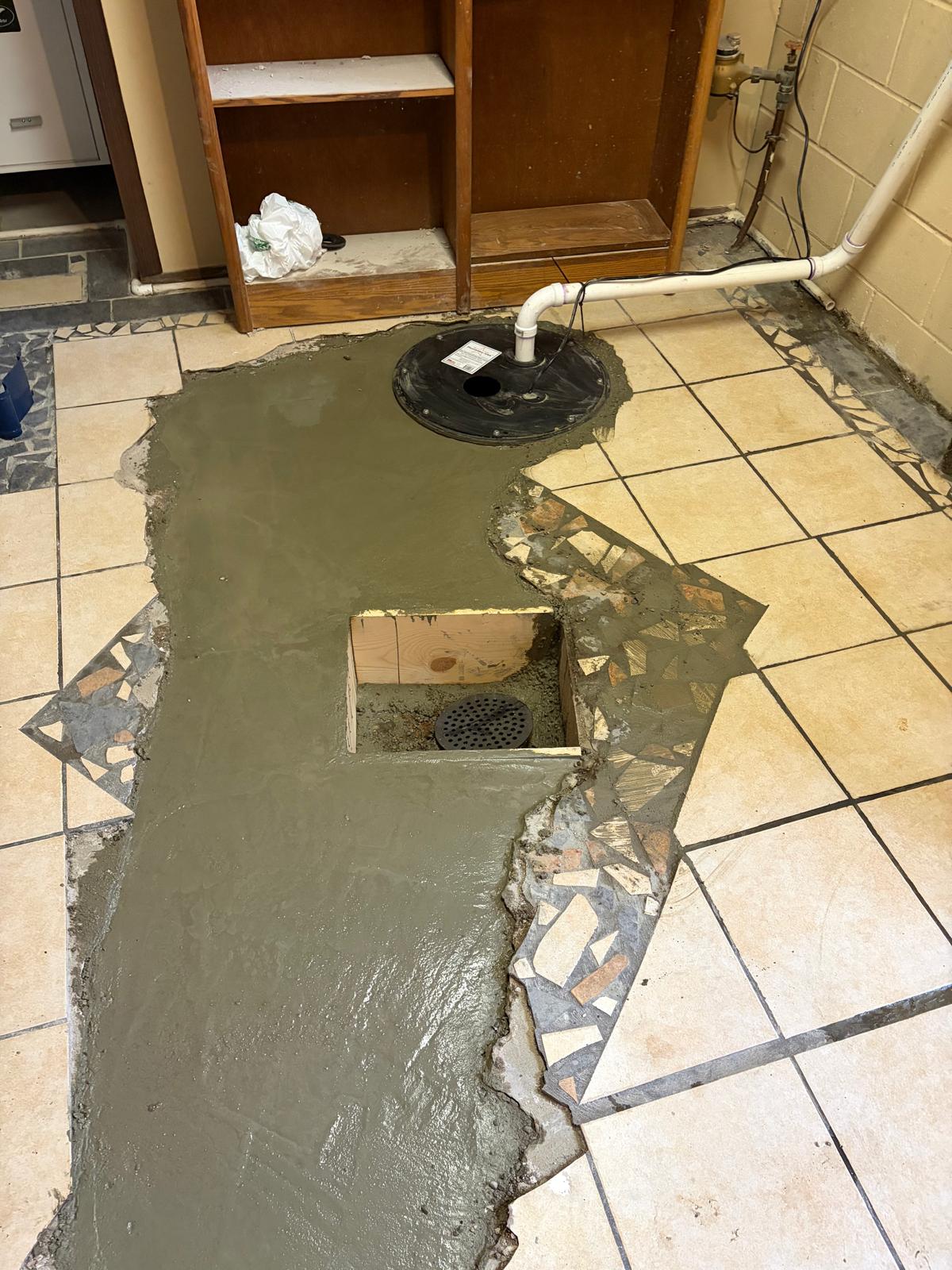 Before: torn-out flooring and exposed sump pit